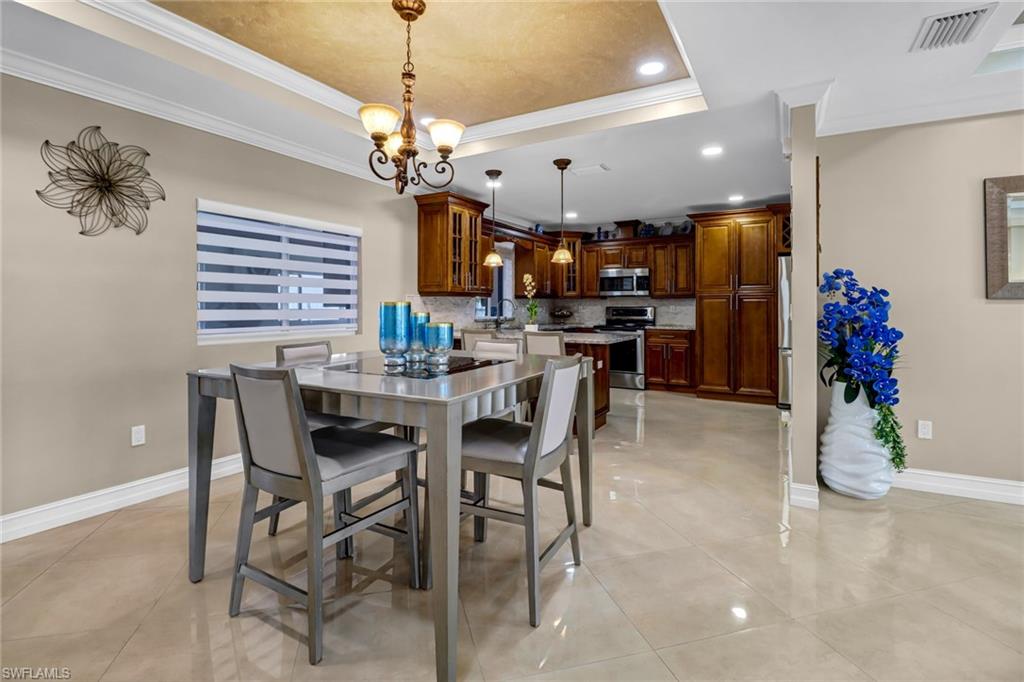 2001 43rd Terrace Southwest Naples, FL 34116 - Photo 9 of 27 a view of a dining room with furniture and chandelier