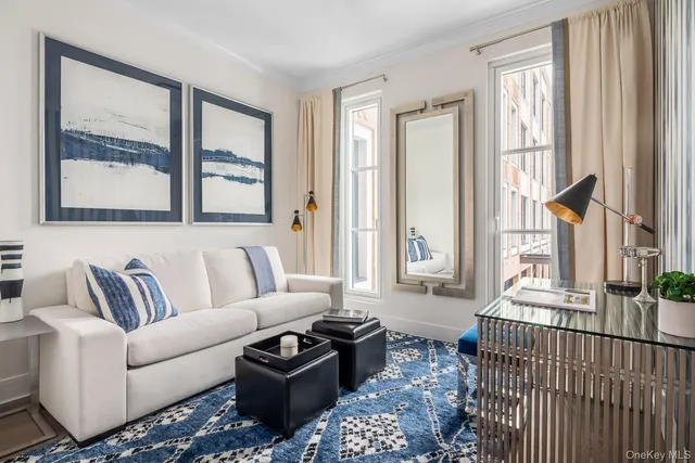 a living room with furniture large window and wooden floor