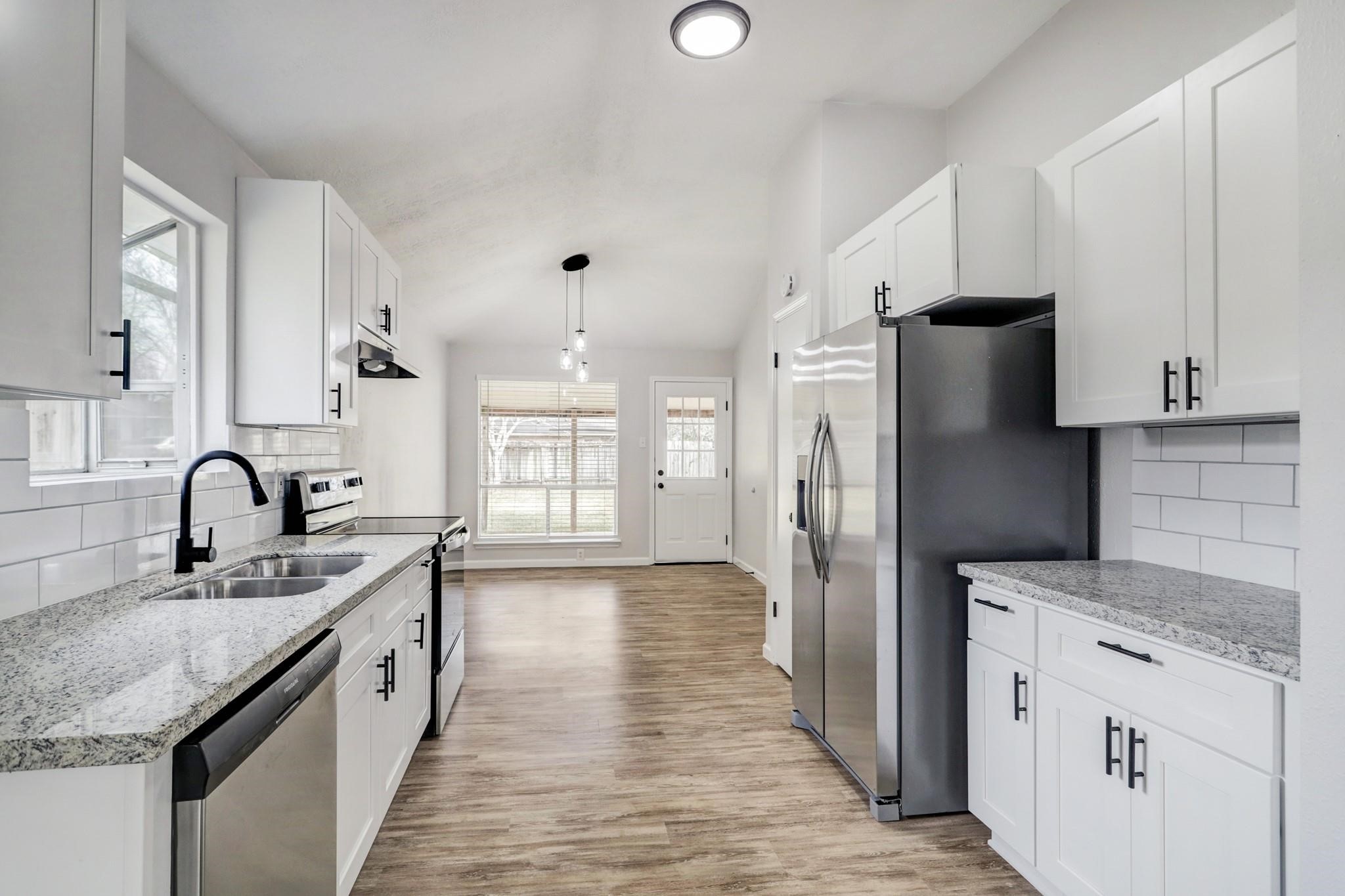15910 Plover Court Humble, TX 77396 - Photo 5 of 10 a kitchen with stainless steel appliances granite countertop a sink stove and refrigerator