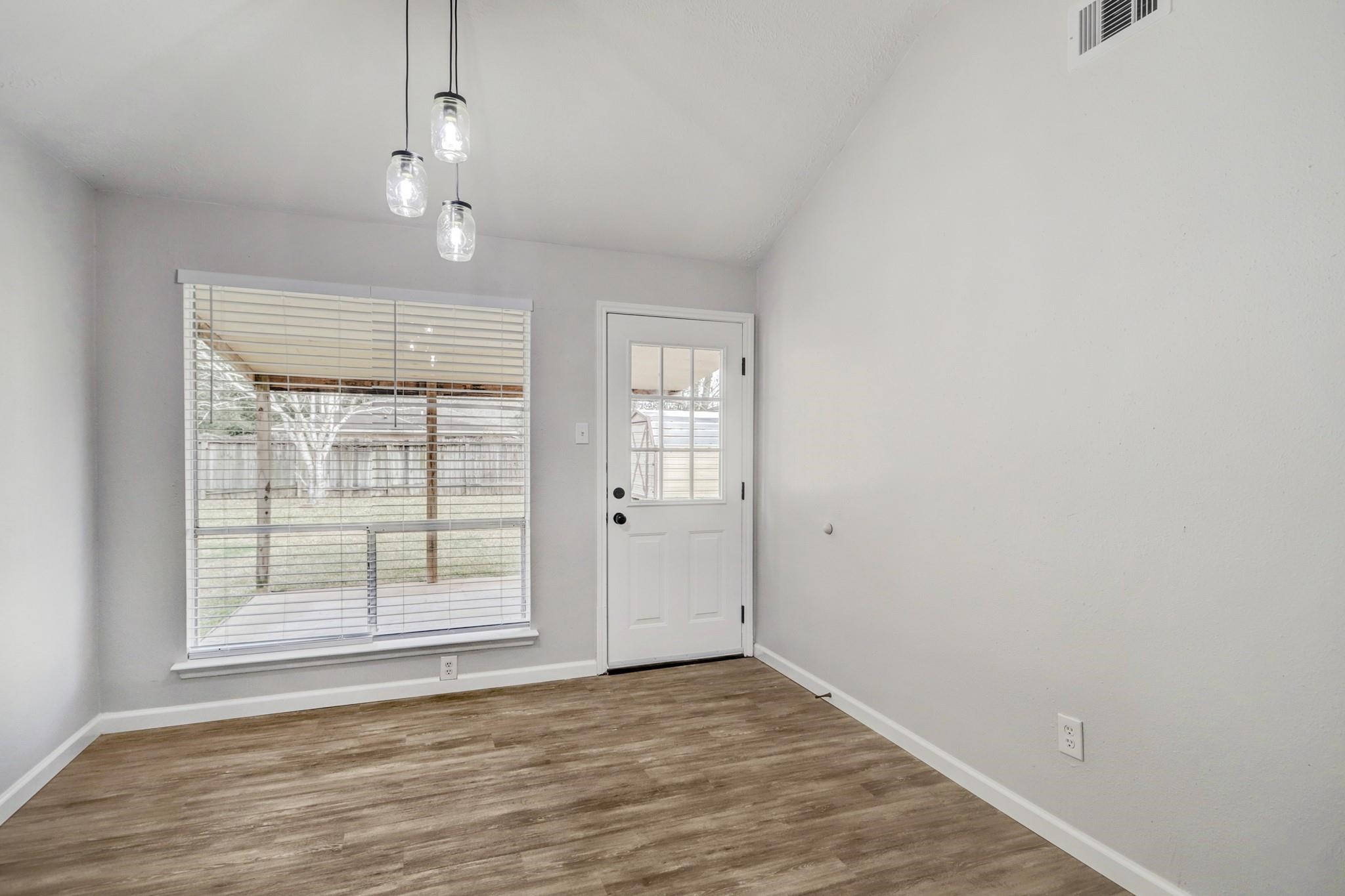 15910 Plover Court Humble, TX 77396 - Photo 7 of 10 an empty room with wooden floor cabinet and windows