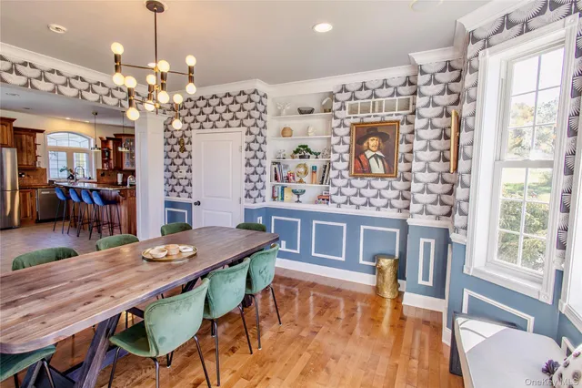 a dining room with furniture a chandelier and wooden floor