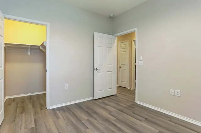an empty room with wooden floor and a sink