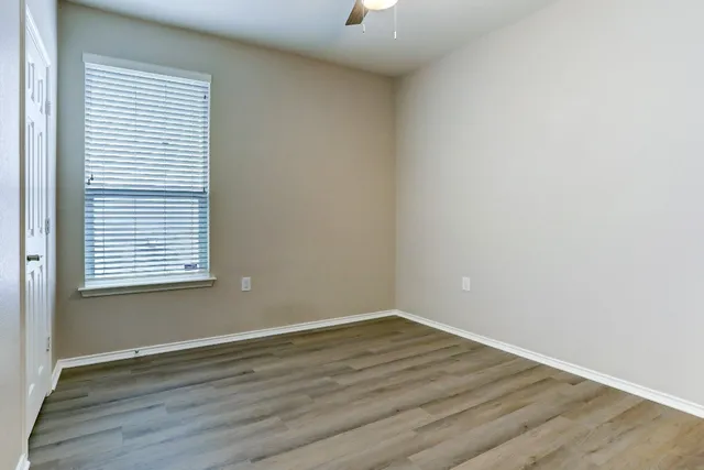 wooden floor in an empty room with a window
