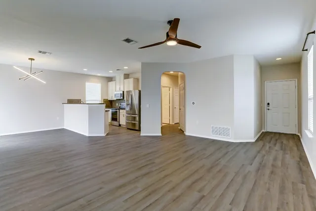 a view of empty room with wooden floor and window