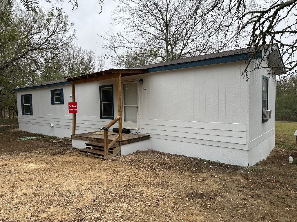 156 Bullfrog Holler Road Dale, TX 78616 - Photo 1 of 10 a backyard of a house with barbeque oven table and chairs