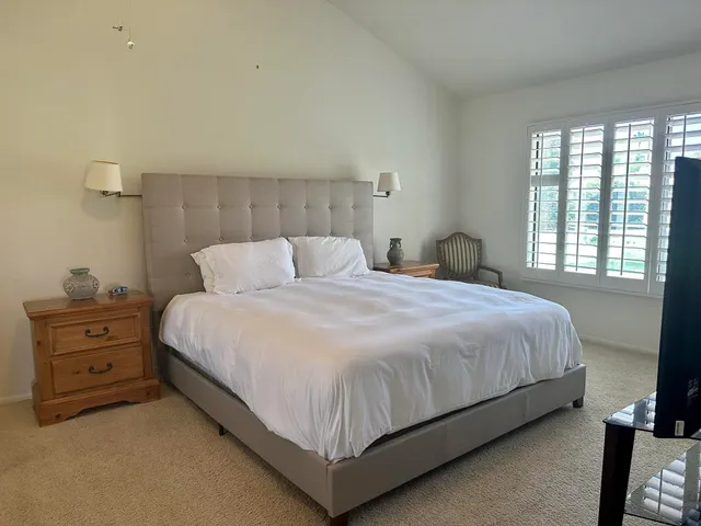 a spacious bathroom with a granite countertop sink a toilet a mirror and shower