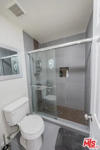 a white toilet sitting next to a shower