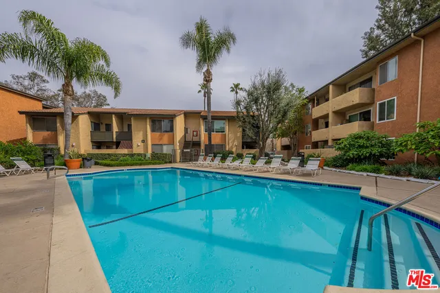 a front view of house and yard with swimming pool and furniture