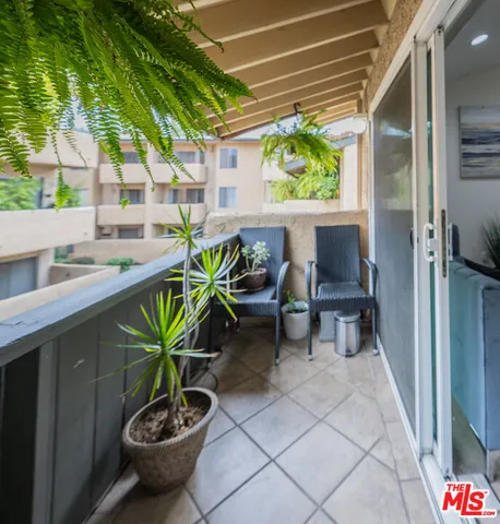 a view of a porch with chairs and potted plants