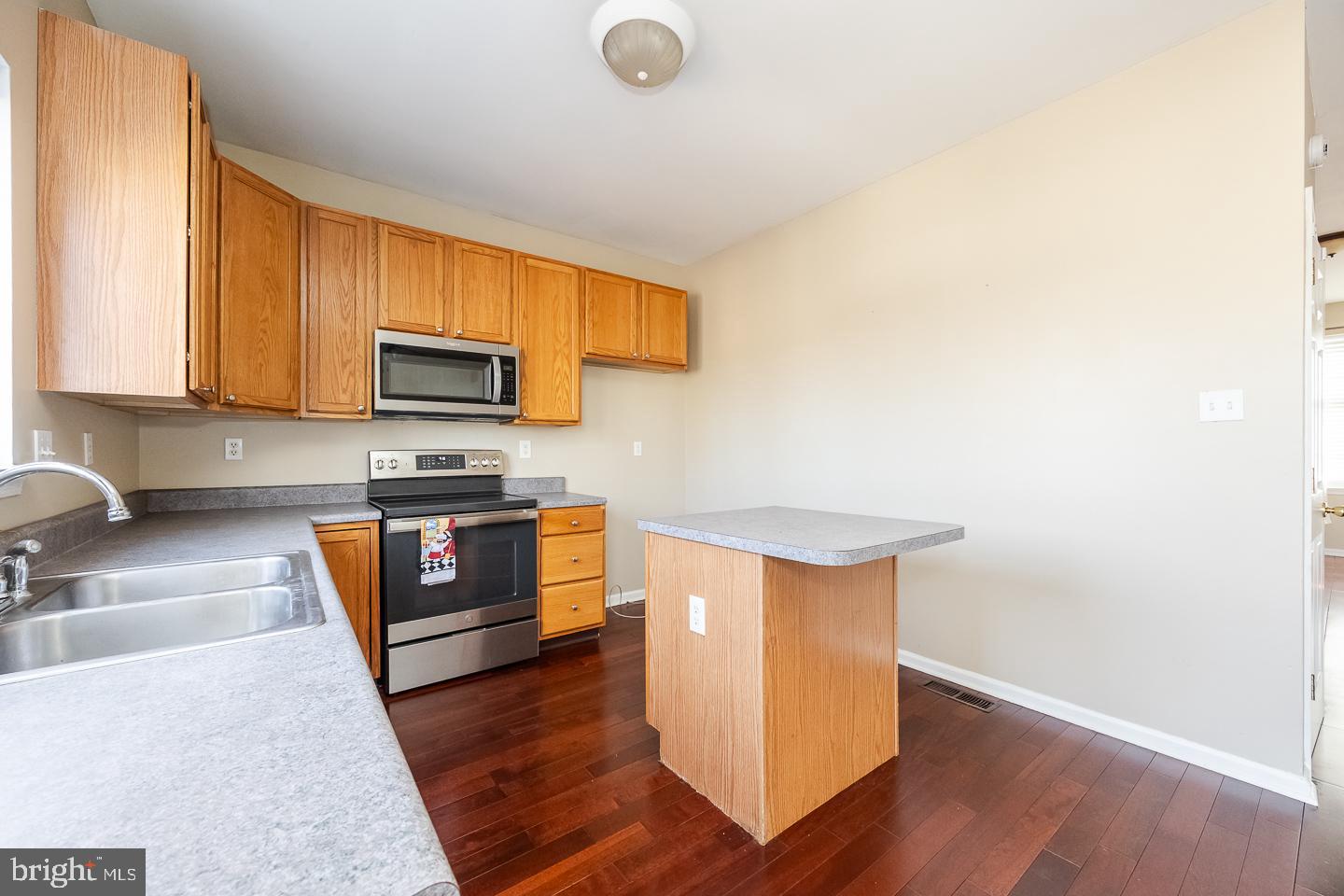 350 Andrew Road Coatesville, PA 19320 - Photo 9 of 20 a kitchen with stainless steel appliances a stove a sink dishwasher and a microwave with wooden floor