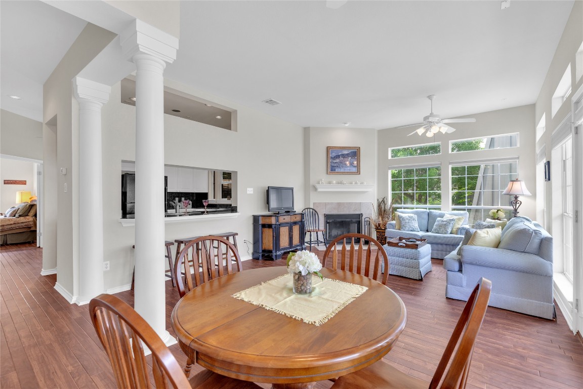 2918 Ranch Road 620 North, Unit L173 Austin, TX 78734 - Photo 6 of 35 Dining area with a ceiling fan, a tile fireplace, decorative columns, wood-type flooring, and baseboards