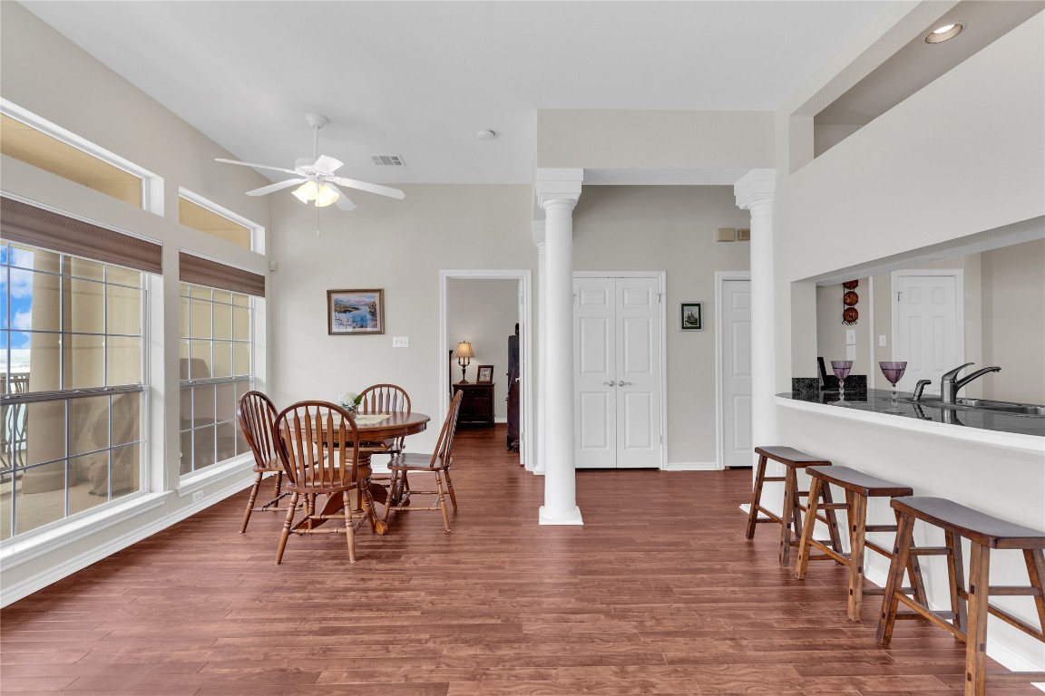 2918 Ranch Road 620 North, Unit L173 Austin, TX 78734 - Photo 8 of 35 Dining area featuring a ceiling fan, wood finished floors, decorative columns, a towering ceiling, and baseboards