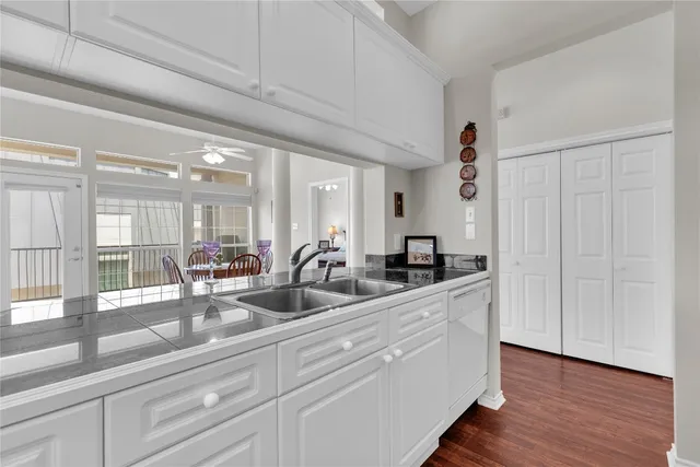 a kitchen with granite countertop a coffee maker a sink a stove and a refrigerator