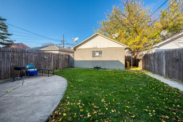 a view of a house with a small yard and a large tree