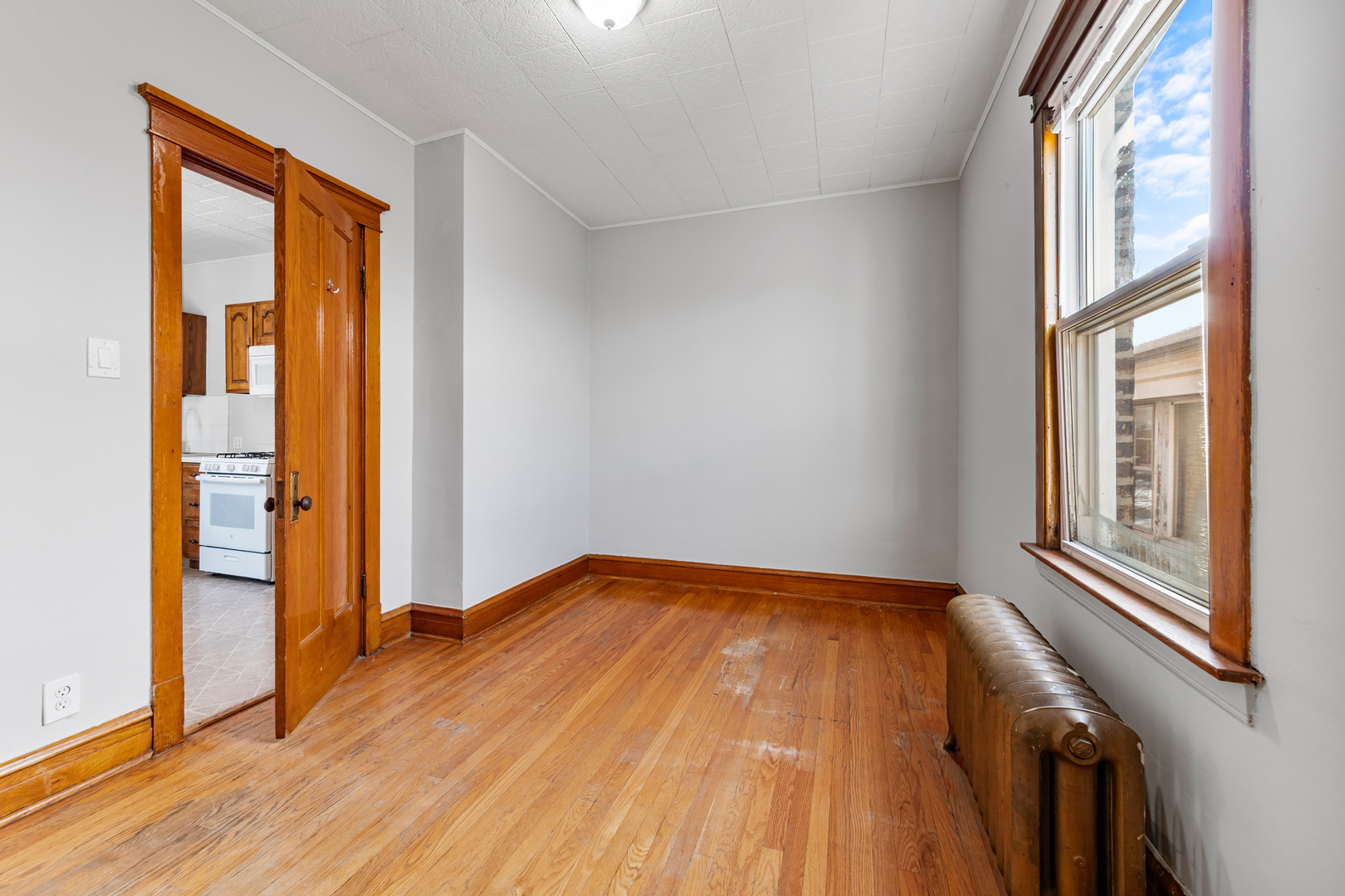 5306 West Roscoe Street, Unit 2 Chicago, IL 60641 - Photo 7 of 12 a view of an empty room with wooden floor and a window