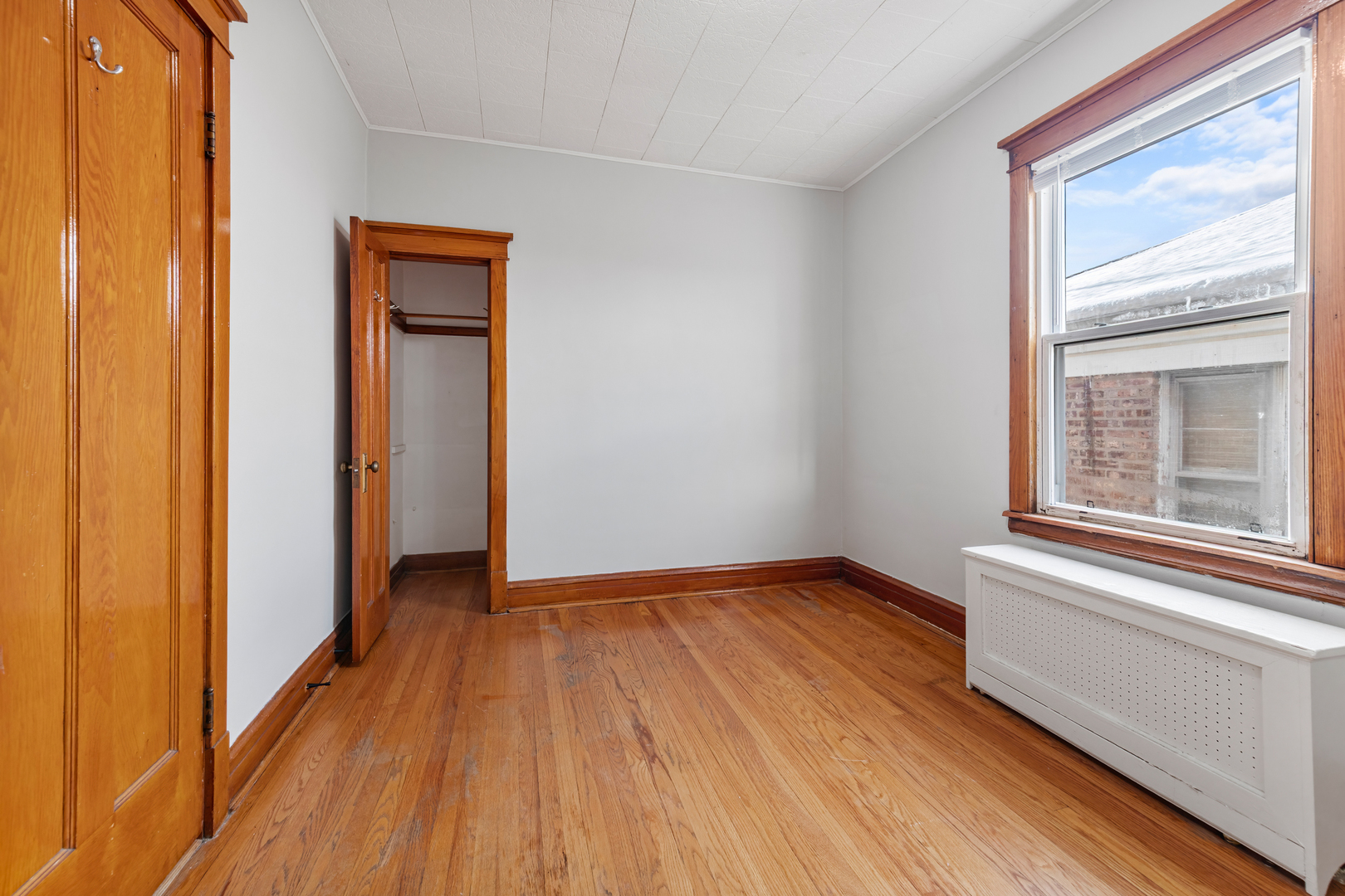 5306 West Roscoe Street, Unit 2 Chicago, IL 60641 - Photo 8 of 12 a view of an empty room with wooden floor and a window