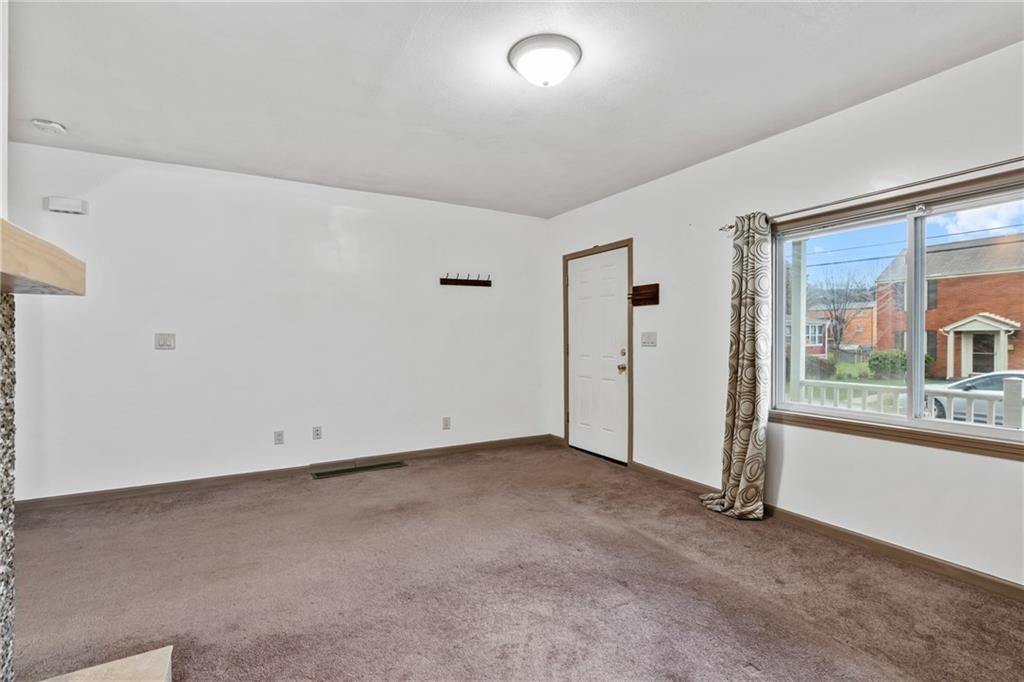 927 Greenhill Road Pittsburgh, PA 15209 - Photo 8 of 41 an empty room with a fireplace and windows