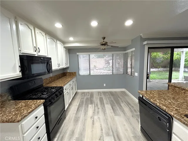 a kitchen with granite countertop a stove sink and cabinets