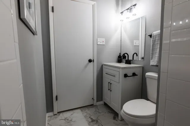 a bathroom with a sink a toilet a mirror and shower
