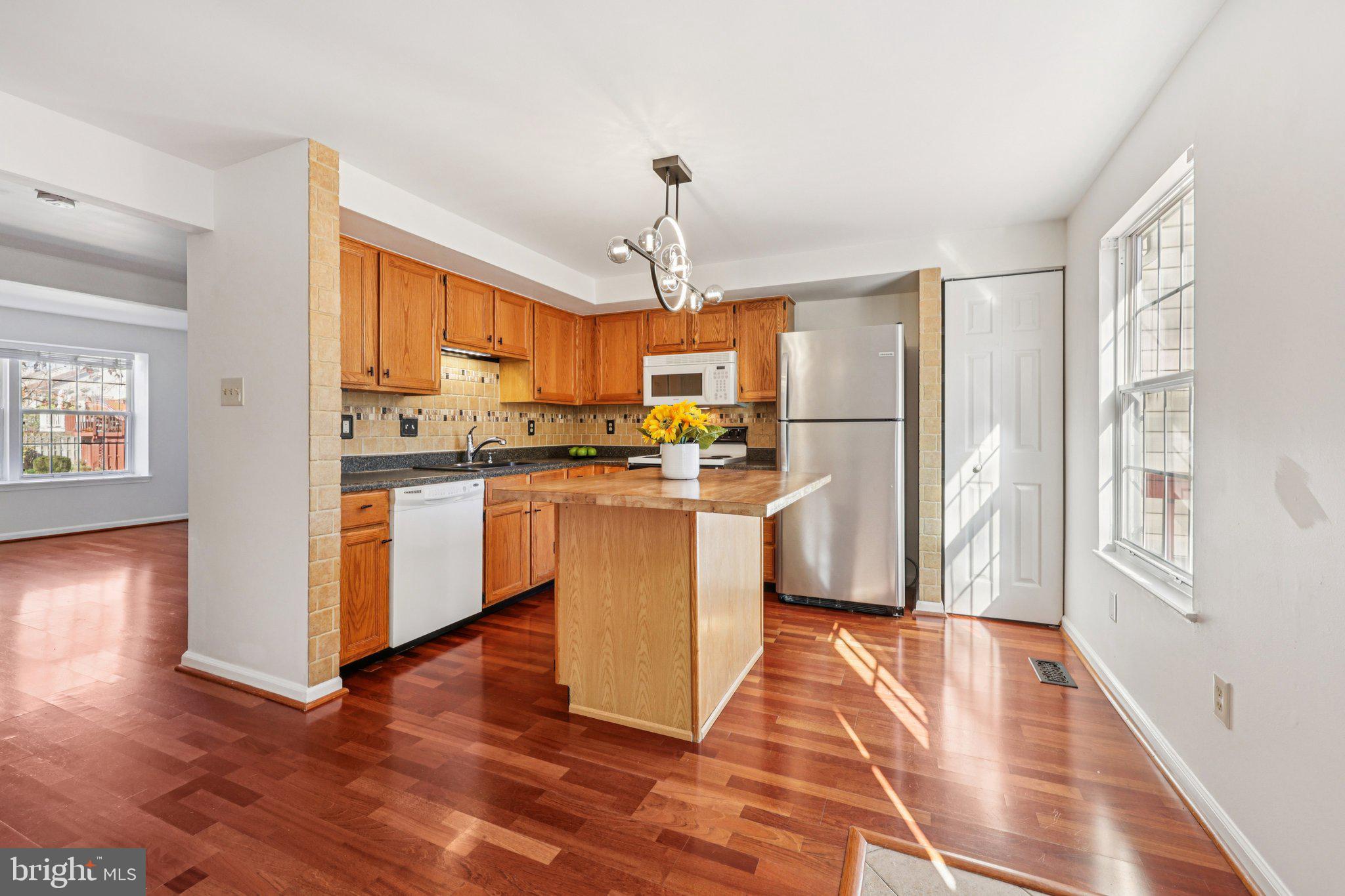 43494 Postrail Square Ashburn, VA 20147 - Photo 16 of 38 a kitchen with stainless steel appliances granite countertop a refrigerator a sink dishwasher a stove with wooden floor and cabinets