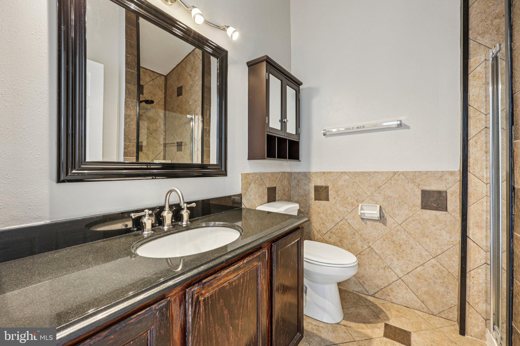 43494 Postrail Square Ashburn, VA 20147 - Photo 32 of 38 a bathroom with a granite countertop sink a toilet and a mirror