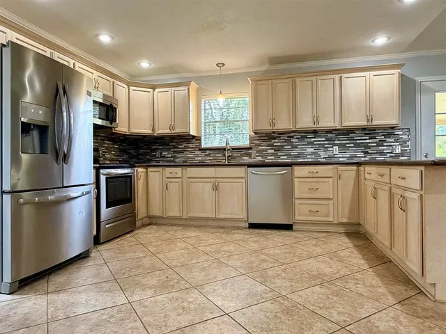 a kitchen with stainless steel appliances a refrigerator sink and microwave