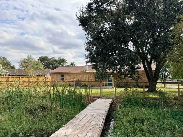 a view of a house with a yard and a fountain