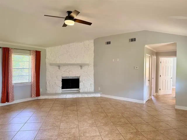 a living room with a fireplace and a floor to ceiling window