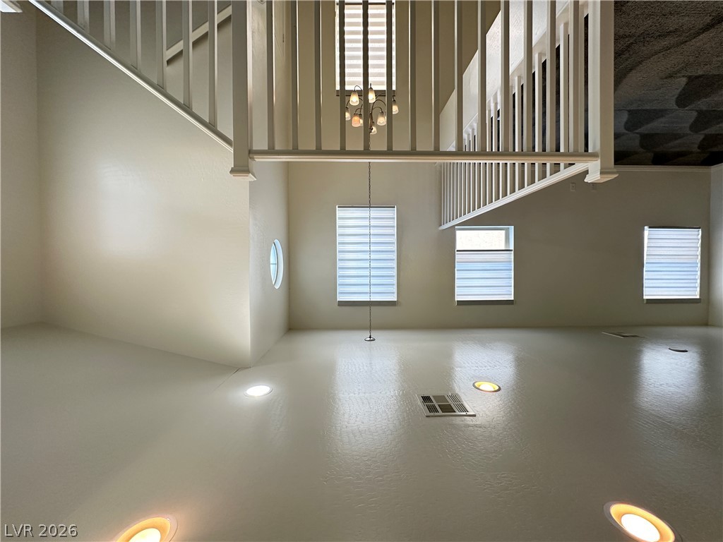 6784 Pivot Point Street Las Vegas, NV 89148 - Photo 10 of 27 Two-story volume ceiling creates an airy living space, illuminated by recessed lighting and a classic chandelier.