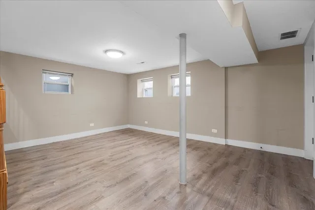 an empty room with wooden floor and door