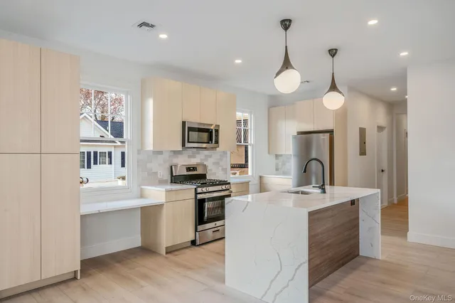 a large white kitchen with lots of counter space sink and appliances