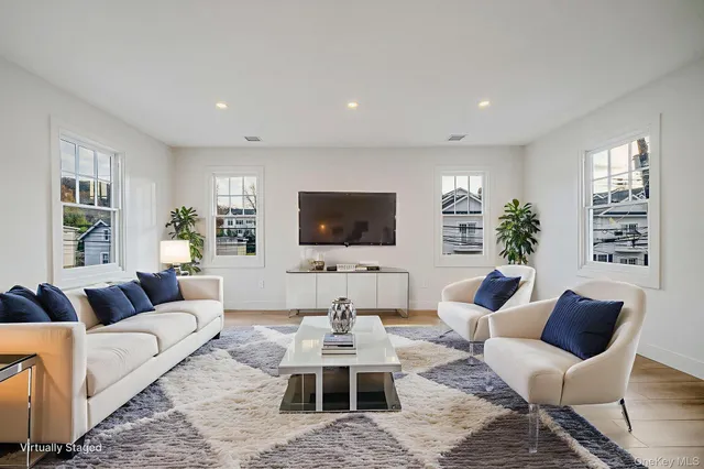 a living room with furniture a flat screen tv and a large window