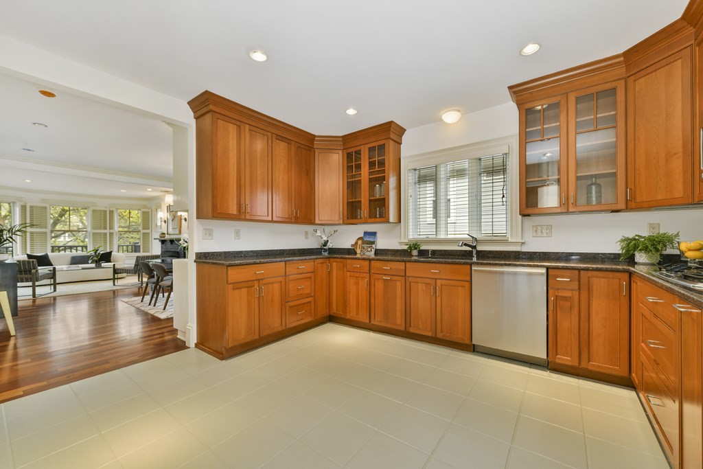 35 Blakeslee Street Cambridge, MA 02138 - Photo 16 of 31 a large kitchen with stainless steel appliances granite countertop a stove a sink dishwasher and wooden cabinets with large window