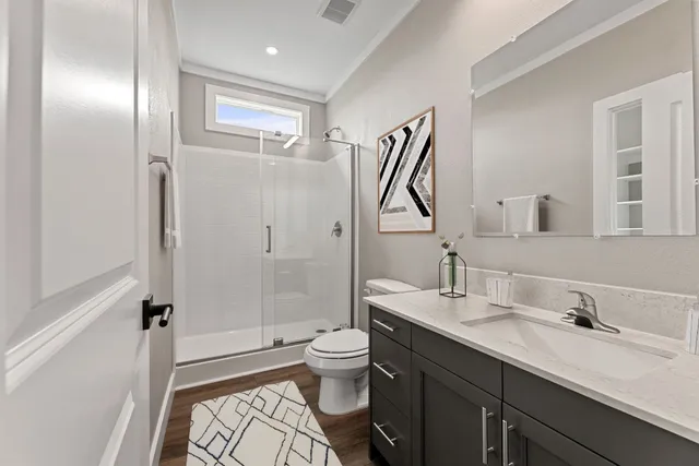 a bathroom with a double vanity sink toilet and shower