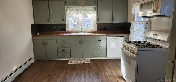a kitchen with a wooden floor and a stove top oven