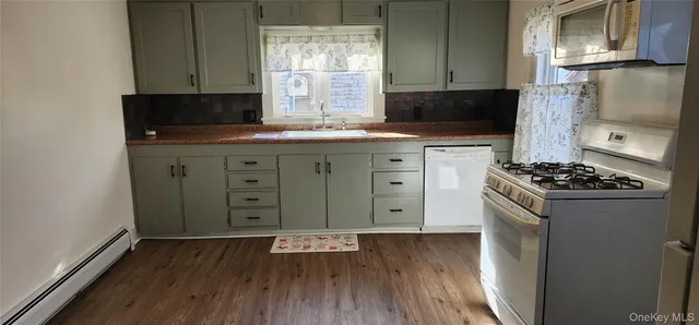 a kitchen with a wooden floor and a stove top oven