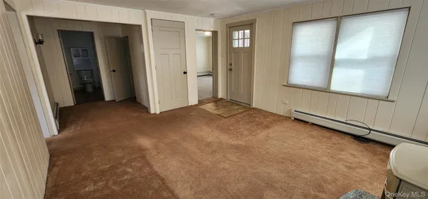 a view of an empty room with glass door and a window
