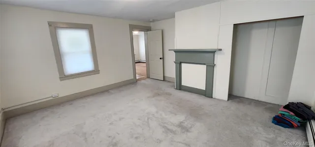 a view of an empty room with window and closet area