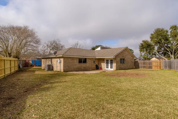 a front view of house with yard and trees in the background