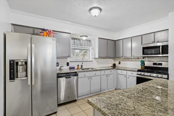 a kitchen with stainless steel appliances granite countertop a refrigerator stove a sink and dishwasher