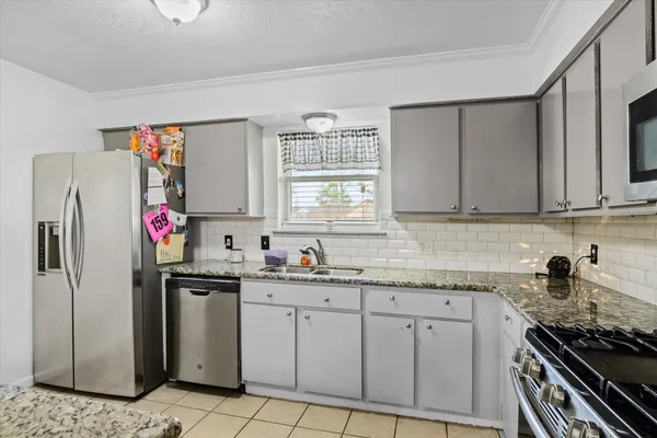 a kitchen with stainless steel appliances granite countertop a sink stove and refrigerator