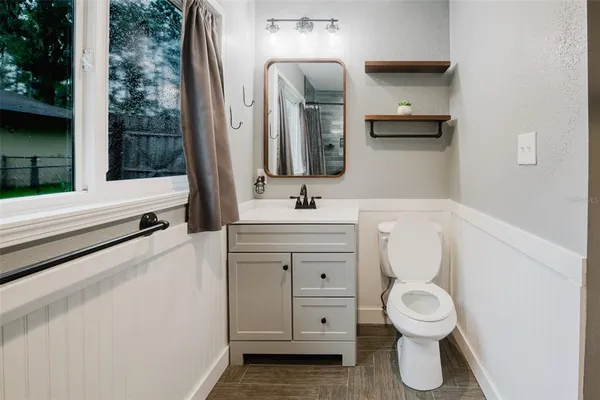 a bathroom with a toilet sink and mirror