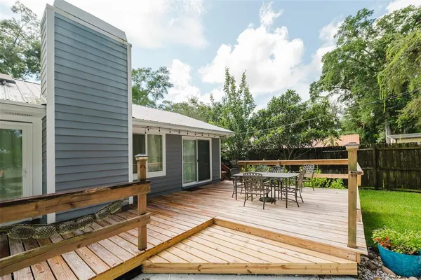 a view of house with deck outdoor seating and yard