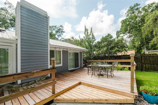 a view of house with deck outdoor seating and yard