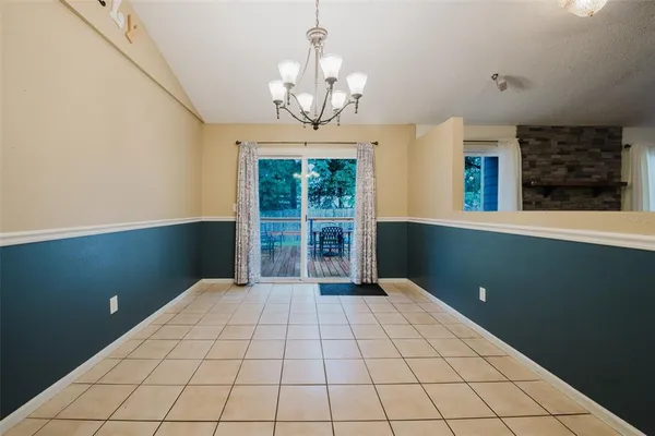 a view of a room with a chandelier fan and windows
