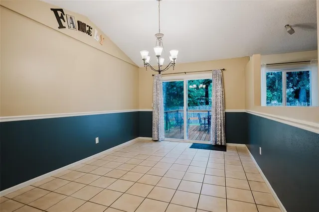 an empty room with wooden floor a fireplace and windows
