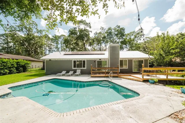 a view of a house with swimming pool and sitting area