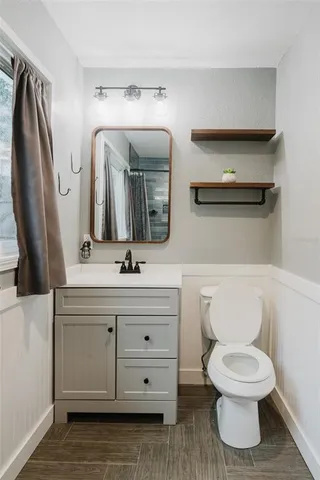 a bathroom with a toilet a sink and mirror