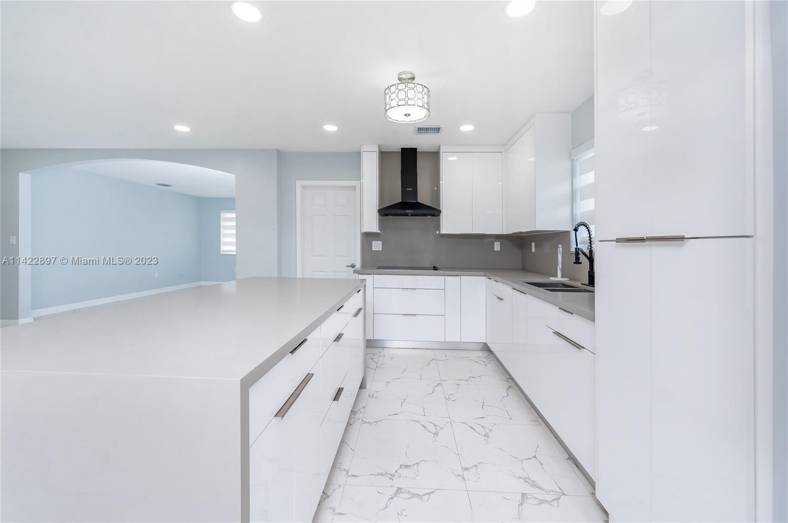 a large white kitchen with cabinets and a stainless steel appliances