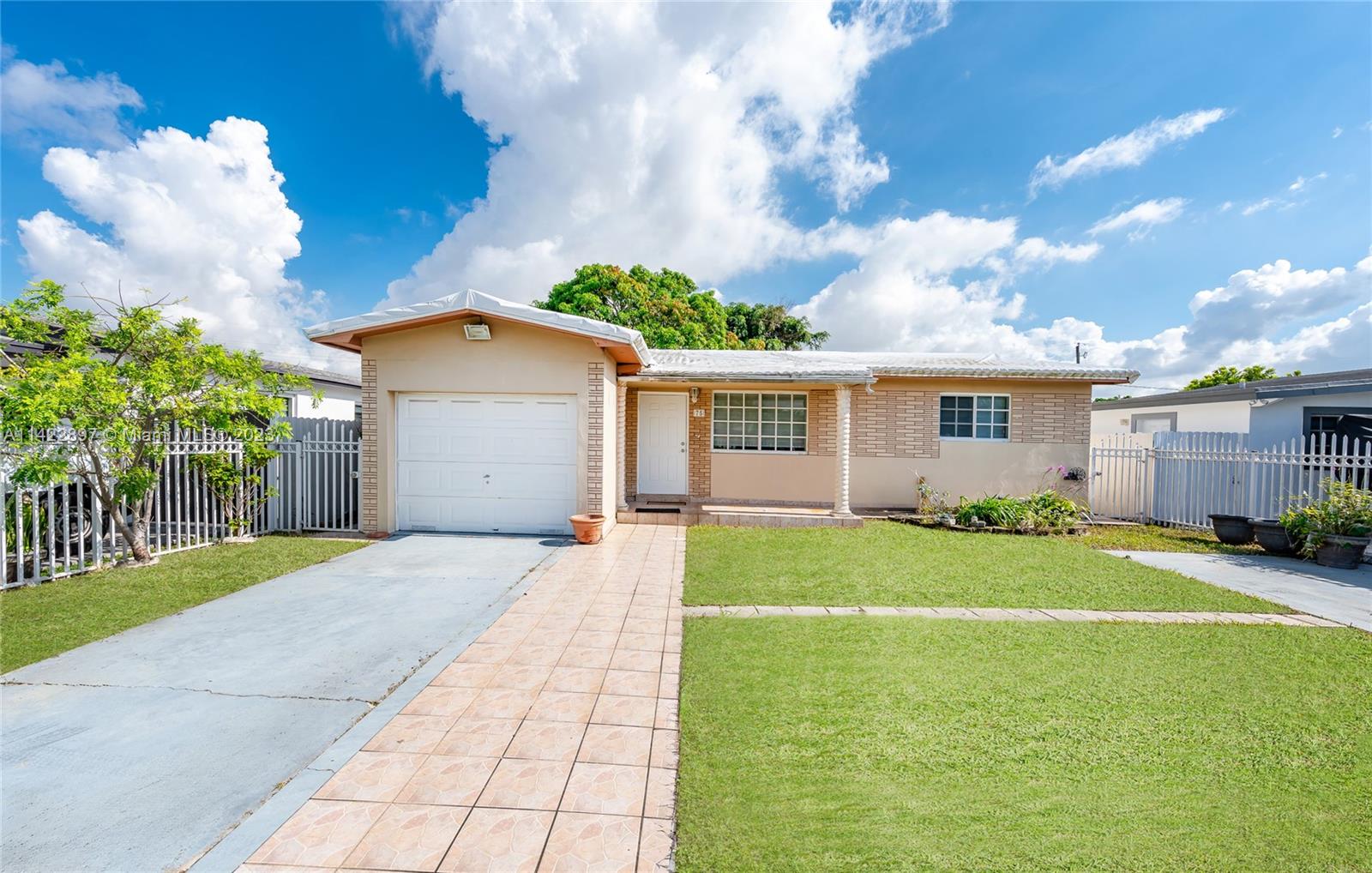 79 West 37th Street Hialeah, FL 33012 - Photo 5 of 28 a front view of a house with a yard and garage